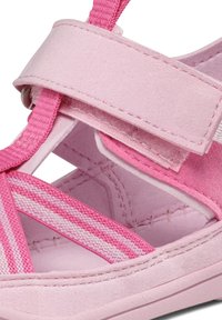 Sandali rosa con morbido camoscio e fasce in tessuto testurizzato con un design a incrocio. Chiusura in velcro e sottili accenti a righe.