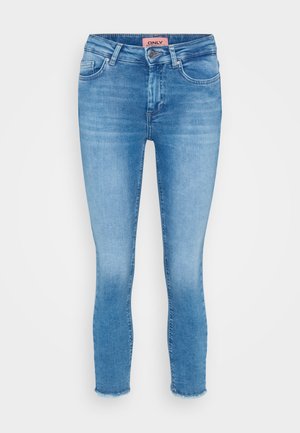 Light blue denim skinny jeans with a mid-rise waist, five-pocket design, and raw hem detail at the ankles. Brand label visible at the waist.