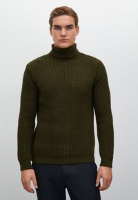 Tumminsweater i mörkgrön, strukturerad stickning, åtsittande form, ribbade muddar och nederkant, minimalistisk design utan synliga dekorationer.