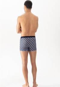 Boxershorts i ett geometriskt, flerfärgat mönster av blått, rosa och kräm, med ett marinblått midjeband; medellång och åtsittande design.