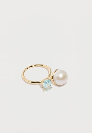 Gold open ring featuring a large white pearl on one end and a square-cut light blue gemstone on the other, set against a white background.