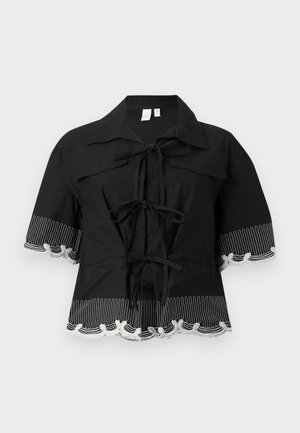 Μαύρο μπλουζάκι με κοντά μανίκια και λευκή κεντητή διακόσμηση σε κυματιστές γραμμές στα μανίκια και το τελείωμα, με τρεις φιόγκους μπροστά και φαρδιά γιακά.