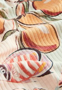 Tissu côtelé doux avec des motifs colorés de poissons et de coquillages dans des tons orange, rouge, vert et crème, créant une surface texturée ondulée.