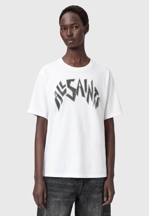 Vit t-shirt med kort ärm som har en svart grafisk design med skarpa kanter. Tillverkad i bomull med klassisk rund halsringning och avslappnad passform.