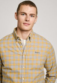 Geel en grijs geruit overhemd met button-down kraag, zachte textuur, knoopsluiting aan de voorkant en geborduurd logo op de borst.