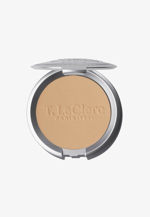 Powder compatto in un elegante astuccio metallico argentato, con una superficie liscia beige e il nome del marchio "T. LeClerc" in rilievo sulla parte superiore.