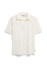 Camicia a maniche corte con colletto in tessuto bianco sporco dalla texture liscia. Presenta otto bottoni lungo la parte anteriore e una piccola etichetta sull'orlo.