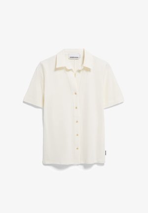 Kurzärmliges, kragenloses Hemd aus off-weißem Stoff mit glatter Textur. Verfügt über acht Knöpfe an der Vorderseite und ein kleines Etikett am Saum.