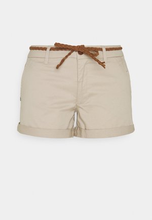 Beige damesshorts met omgeslagen zomen en een bruine gevlochten riem die in een strik is geknoopt aan de taille.