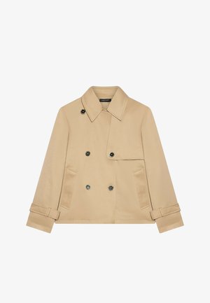 Vaahto-beige kaksirivinen takki, jossa on jämäkkä kaulus, kaksi etutaskua ja koristepainikkeita; sileä kangas ja istuva malli.