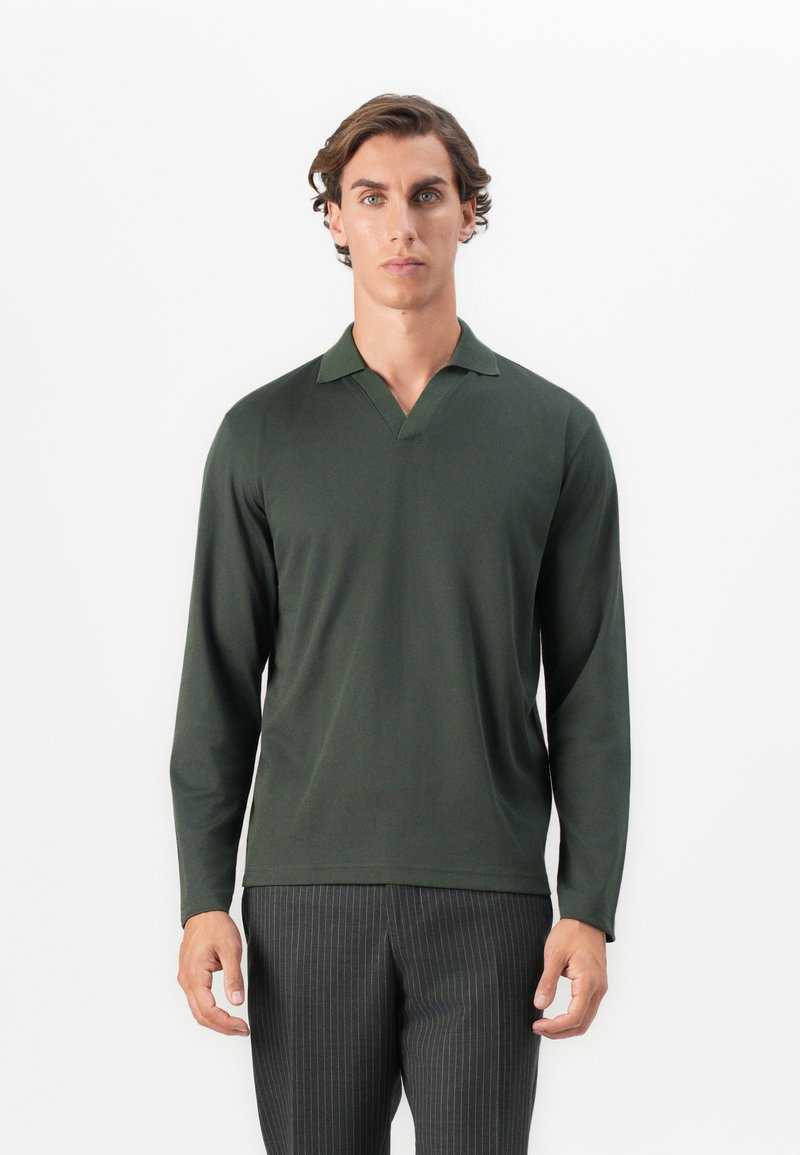 Mørkegrøn langærmet polo-shirt med V-hals og ribbet krave, lavet af glat stof. Bæres med stribede bukser.