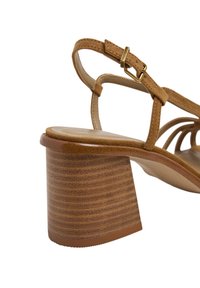 Sandale marron avec un design à brides, une finition en daim texturé et un talon bloc rayé style bois. Détail de boucle réglable inclus.