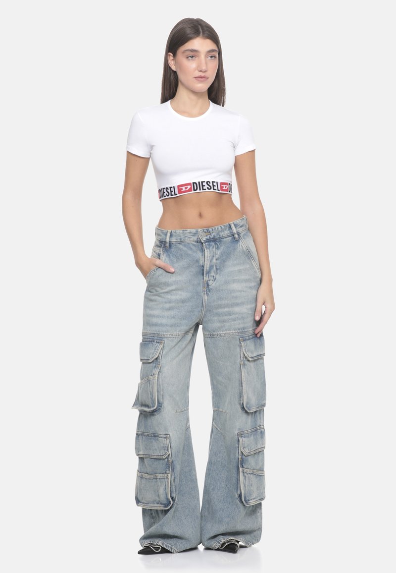 T-shirt bianca a maniche corte con una fascia logata nera e rossa. Jeans cargo blu chiaro con più tasche, vestibilità ampia, texture di denim sbiadito.