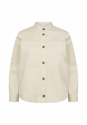 Beige skjorta med ståkrage, två framfickor och bruna knappar. Tillverkad av ett mjukt, lätt tyg.