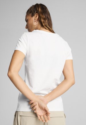 Hvid bomulds t-shirt med korte ærmer og rund halsudskæring, der har et enkelt design. Bagfra ses en afslappet pasform og en glat tekstur.