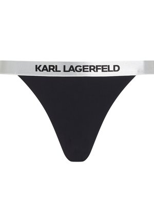 Zwarte stringonderbroek met een brede, zilveren elastische tailleband waarop "KARL LAGERFELD" in zwart is gedrukt. Glad materiaal, minimaal ontwerp.
