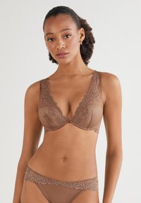 Brun blonde bralette med en dyb udskæring, tekstureret stof og brede blonde stropper, parret med matchende trusser med blondekant.