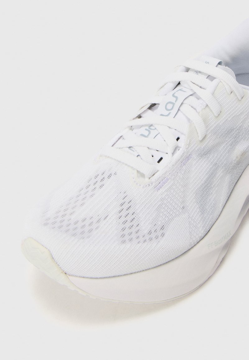 Weißer Sportschuh mit Obermaterial aus Mesh, runder Zehenform und flachen Schnürsenkeln. Verfügt über dezente Musterung und eine leichte, gepolsterte Sohle.