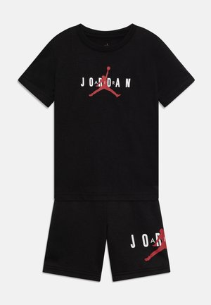 Crni pamukasti komplet majice kratkih rukava i šorts, s bijelo-crvenim grafičkim natpisom "JORDAN" i ikonskim Jumpman logom.