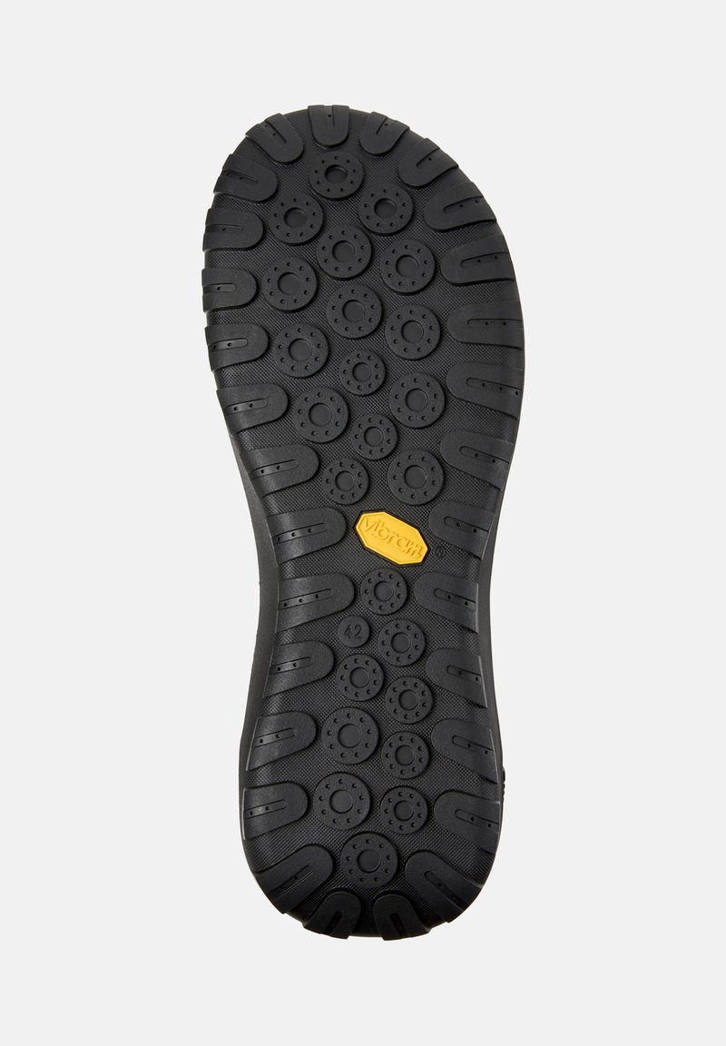 Black rubber shoe sole with a textured surface, featuring circular patterns and a Vibram logo in yellow. Size indicated as 42.