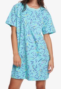 Robe oversized à manches courtes en tissu bleu clair avec des motifs abstraits violets et jaunes, encolure ronde et coupe décontractée.