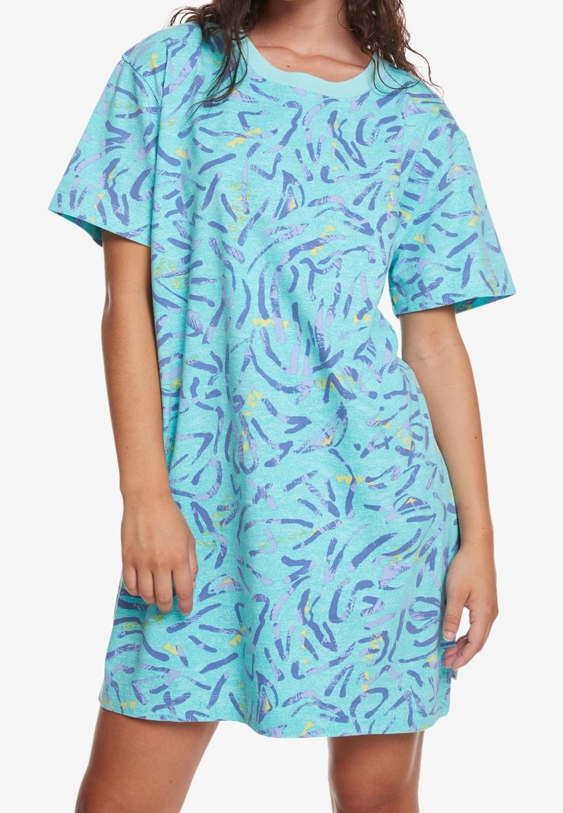 Robe oversized à manches courtes en tissu bleu clair avec des motifs abstraits violets et jaunes, encolure ronde et coupe décontractée.