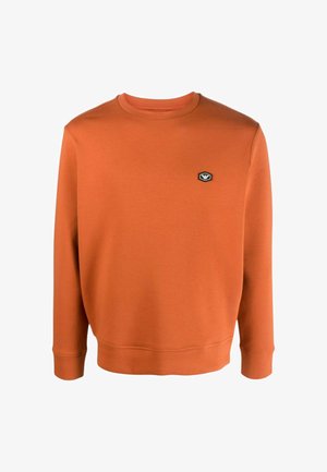 Felpa arancione a maniche lunghe con collo a giro e polsini e orlo a coste, con una piccola toppa con logo bianco e nero sul petto a sinistra.