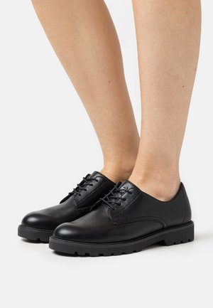 Black leather lace-up shoes with a smooth texture, solid design, round toe, and a rugged rubber sole. Features subtle stitching details.