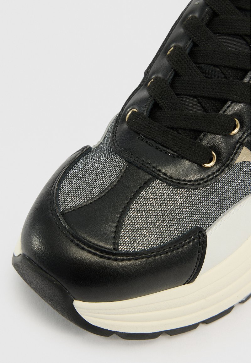 Schwarze Leder- und Metallgewebe-Sneaker mit einem strukturierten Muster, flachen schwarzen Schnürsenkeln, goldenen Ösen und einer weißen Gummisohle.