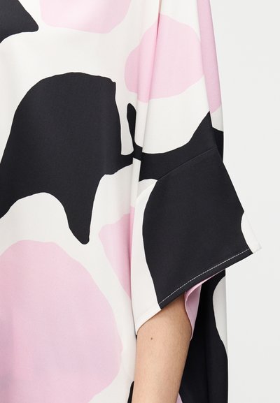 Χαλαρή μπλούζα με κοντά μανίκια, με αφηρημένο μαύρο, ροζ και λευκό σχέδιο σε λείο ύφασμα. Διακριτές κοντράστ ραφές.