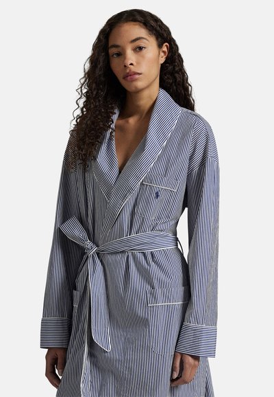 Ριγέ βαμβακερό μπουρνούζι σε ναυτικό μπλε και λευκό, με ζώνη δέσιμο, γιακά με πέτο, μακριά μανίκια και τσέπες μπροστά.