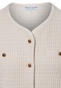 Gewebte beige Strickjacke mit einem strukturierten Muster, ausgestattet mit goldenen Knöpfen und zwei vorderen Taschen. Das Etikett trägt die Aufschrift "Marie Lund, Kopenhagen, S."