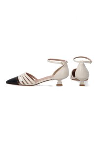 Spitz zulaufende Absatzschuhe mit einer schwarzen lackledernen Spitze, einem cremefarbenen Riemendesign und einem niedrigen Blockabsatz. Enthält verstellbare Knöchelriemen.