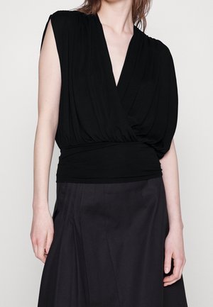 Black top with a deep V-neck and pleated design. Soft fabric drapes gently over the waist, featuring short sleeves and a fitted band at the bottom.