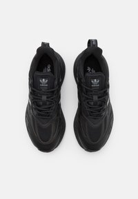 Svarta sportskor med övre del i mesh och syntetmaterial, med texturerade accenter, vadderad krage och logotyp på tungan och hälen.
