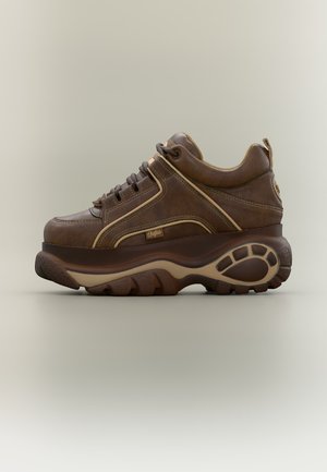 Brun skinnplattform-sneaker med tykk gummisåle, beige detaljer, snøring foran og liten "Buffalo"-logo på siden.