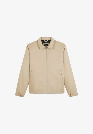 Veste beige à zip avec un col, deux poches latérales et des poignets élastiques. Tissu lisse et design minimaliste.