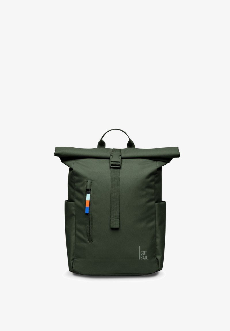 Mochila de color verde oscuro con cierre enrollable, bolsillo delantero con cremallera, bolsillos laterales, una correa con hebilla y un logo "GOT BAG" en la parte inferior derecha.