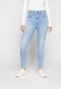 Ljust blå smala jeans med hög midja, med framfickor, knappstängning och en subtilt blekt denimtextur.