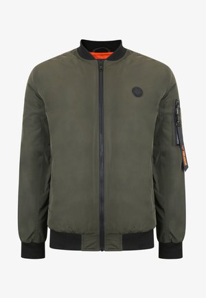 Olivově zelená bomber bunda se zipem v přední části, žebrovanými manžetami a pasem. Má oranžovou podšívku a kapsu na levém rukávu se zipem. Černý detail loga.