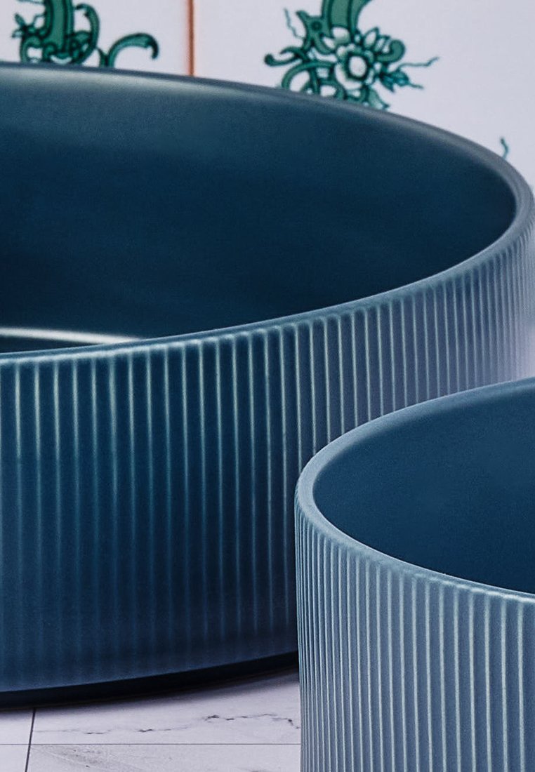 Dunkelblaue Keramischalen mit vertikaler gerippter Textur; eine größere und eine kleinere, mit glatten, abgerundeten Kanten.