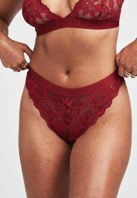 Bordeaux kanten lingerieset met een bloemmotief. De beha heeft een driehoekige vorm met doorzichtig materiaal, en de tailleband is breed en met een logo versierd.
