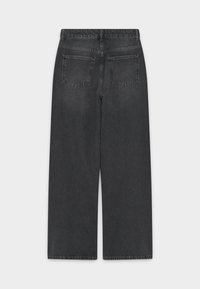 Crne traperice ravnog kroja, sa visokim strukom, dva stražnja džepa i vidljivim šavovima duž pojasa i ruba.