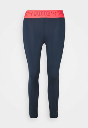 Marineblauwe leggings met een roze PUMA-logo op de tailleband, gemaakt van rekbaar materiaal, met een aansluitend ontwerp en een gladde textuur.