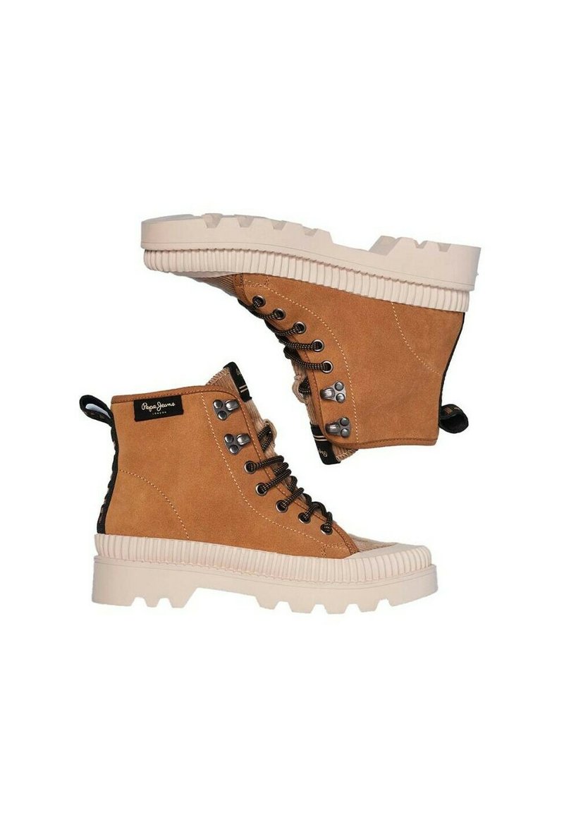 Botas de tobillo de ante en color marrón claro con una suela de goma blanca gruesa, cordones negros y ojales de metal. Presenta una etiqueta de logo y un panel trasero texturizado.