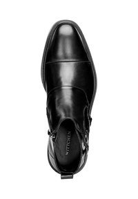 Botín negro de cuero hasta el tobillo que presenta un diseño elegante, puntera afilada, detalle de doble hebilla y forro texturizado. Apariencia sofisticada y pulida.