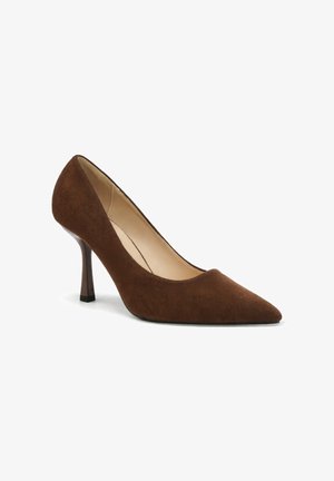 Chaussure à talon haut à bout pointu en daim marron pour femme avec un talon fin et effilé sur fond blanc.