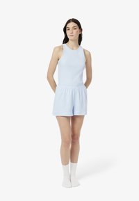 Conjunto casual azul claro que incluye una blusa sin mangas y pantalones cortos a juego. La tela parece suave con un ajuste relajado y una cintura elástica.