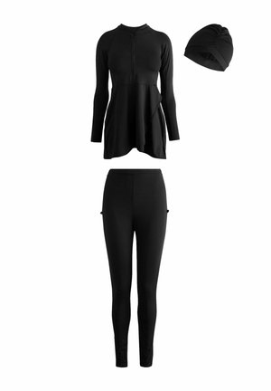 Maglia a maniche lunghe nera con zip frontale, leggings neri e cuffia da nuoto nera arricciata, disposti su sfondo bianco.