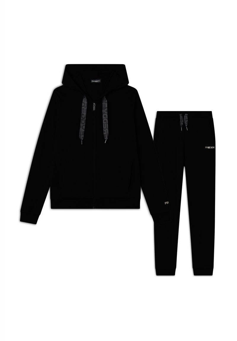 Set di felpa nera e pantaloni jogger realizzati in tessuto morbido. La felpa presenta una chiusura a zip e cordini con logo. I pantaloni jogger hanno una silhouette aderente.